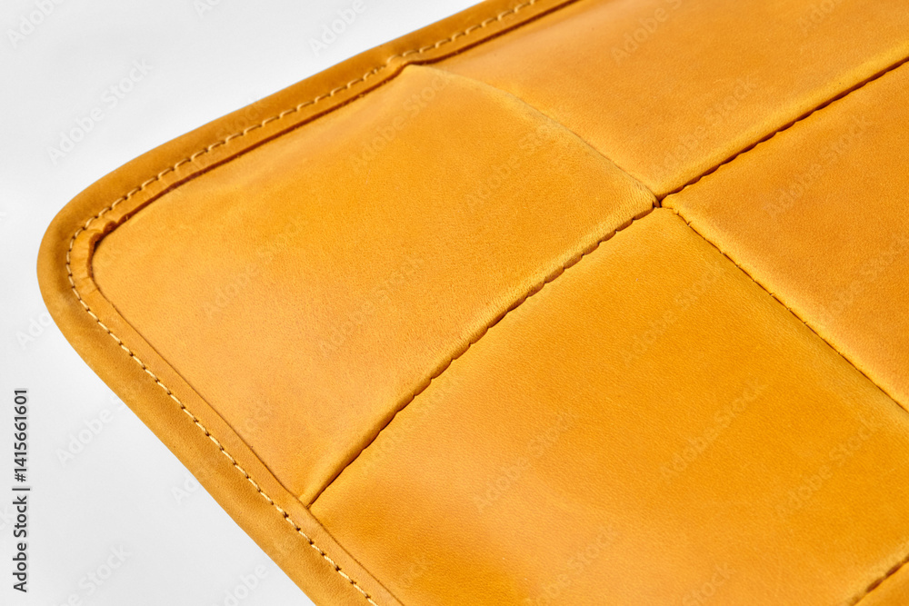 Close-up of stitching detail highlighting the craftsmanship of yellow leather upholstery