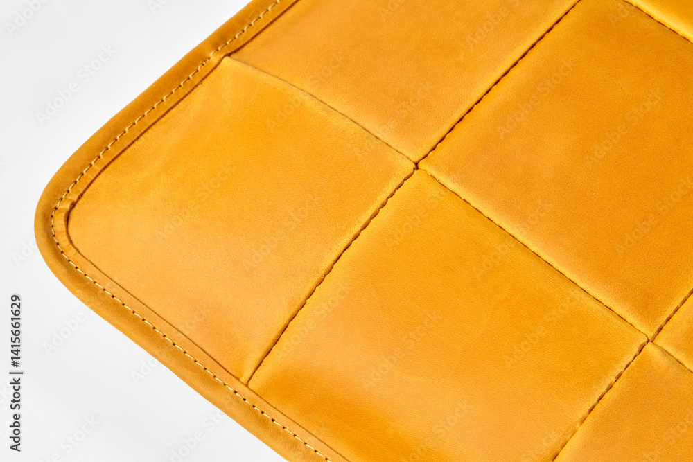 Close-up of mustard yellow leather upholstery showing stitching detail