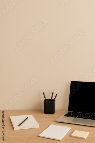 Home Workspace Featuring a Laptop, Notebooks, and a Pen Holder on a Wooden De...