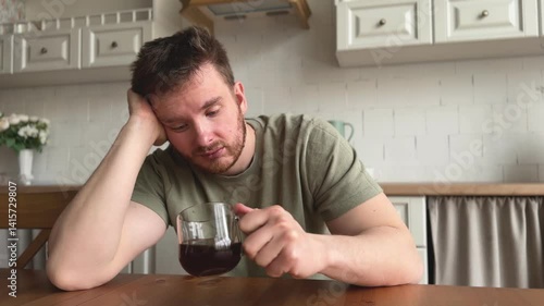 man suffering from lack of sleep and depression in the kitchen in the morning