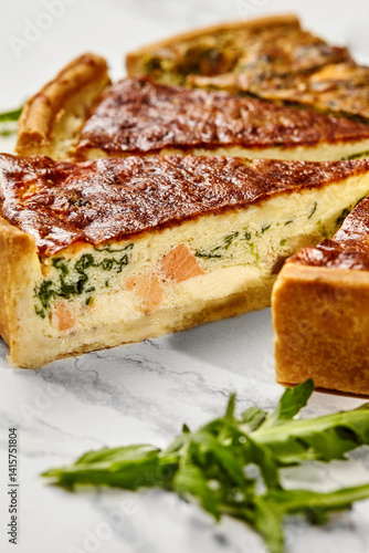 Delicious homemade salmon and spinach quiche resting on a marble surface