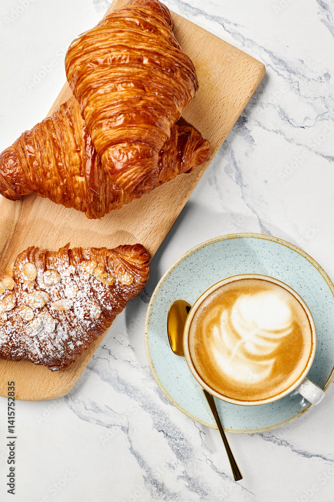 Delicious french croissants and cappuccino resting on marble table