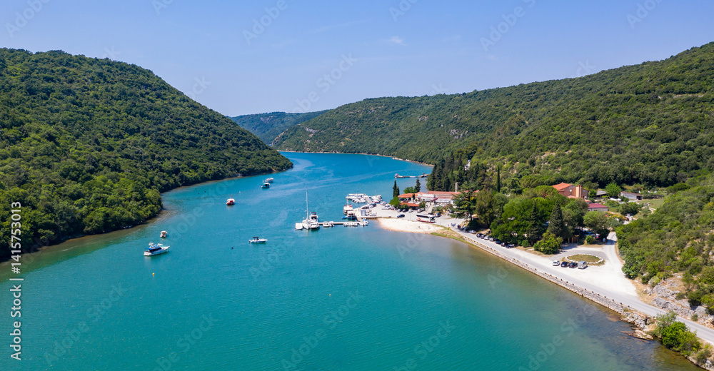Fototapeta premium Aerial drone view of the sea and islands. High-resolution top-down drone shot of sea, sky, islands and clear sky. Soft lighting ideal for travel, landscape or nature themes.