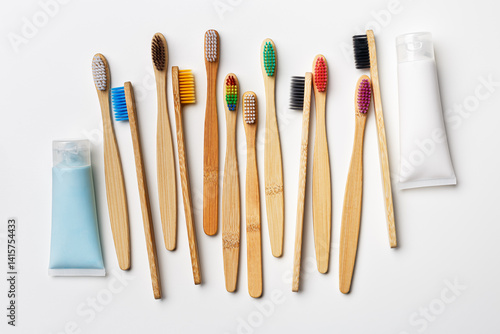 Obraz na płótnie Top view of eco-friendly bamboo toothbrushes with colorful bristles and toothpaste tube on white background, Natural organic bathroom beauty product concept, dental hygiene, minimal flat lay w salonie