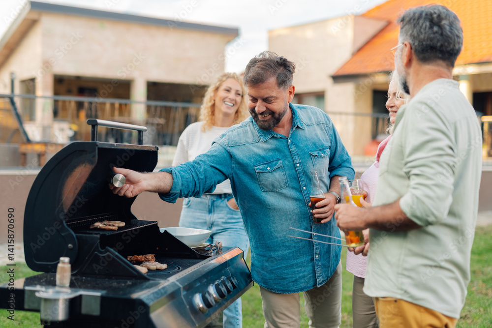 Obraz premium Friends grilling meat and having backyard barbecue party