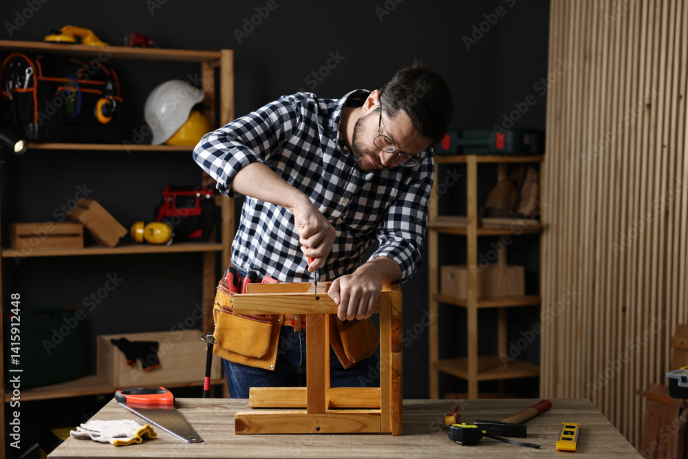 Carpenter repairing stool at table in workshop Carpenter repairing stool at table in workshop