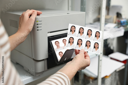 Obraz na płótnie Worker with passport photos of women near modern printer indoors, closeup w salonie