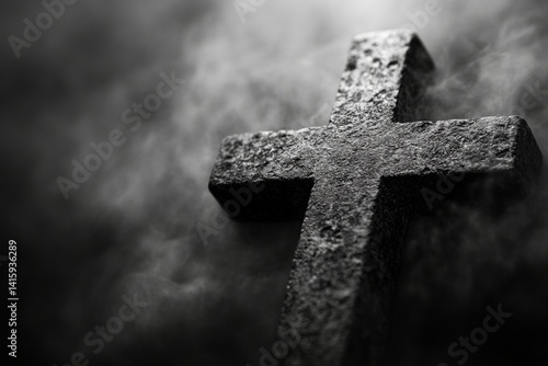 A solitary light source shines down on a somber Christian cross