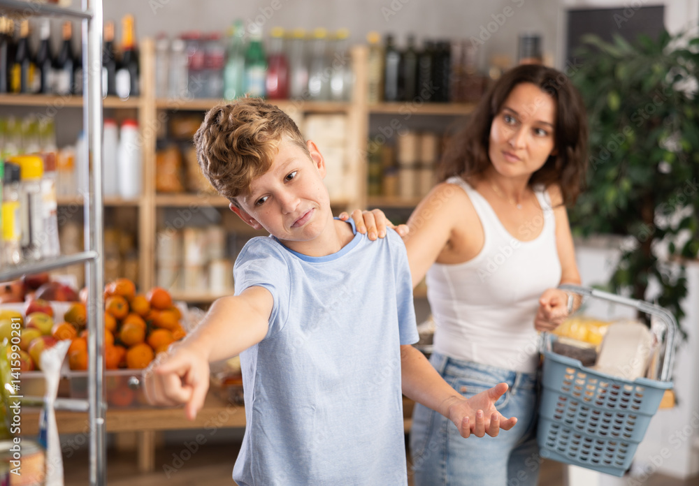 Teenager boy is angry at his mother and does not answer her. Mom persuades stubborn child, explains ban on buying sweets