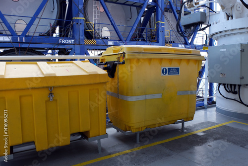 Two yellow SOPEP spill kit as a part of the ship oil pollution emergency plan situated on deck of merchant ship.
