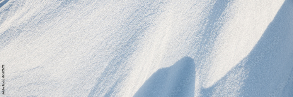 Snow texture. Wind sculpted patterns on snow surface. Wind in the tundra and in the mountains on the surface of the snow sculpts patterns and ridges. Arctic, Polar region. Winter panoramic background.