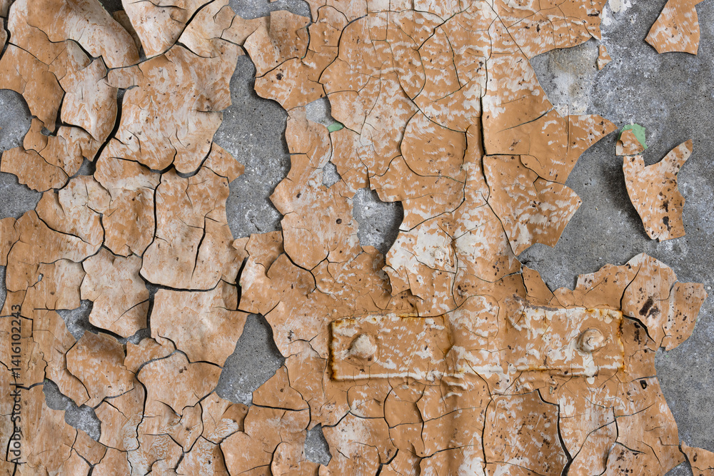 Peeling paint on the wall. Old concrete wall with cracked flaking paint. Weathered rough painted surface with patterns of cracks and peeling. Grunge texture for background and design. High resolution.