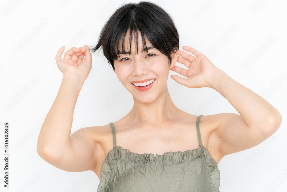 白バックでスキンケアをするショートヘアの若い女性 白バックでスキンケアをするショートヘアの若い女性