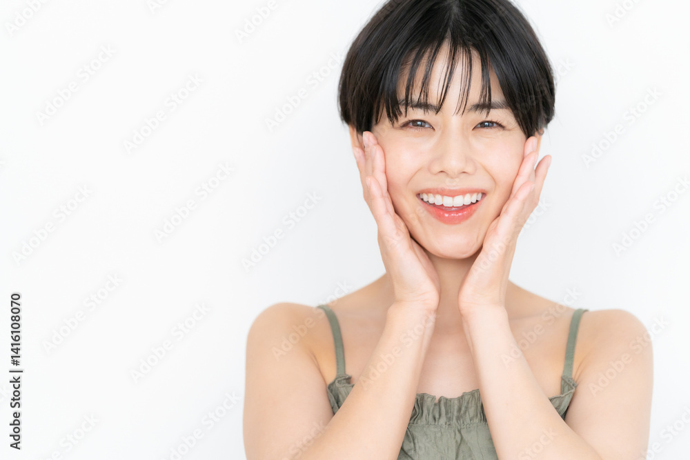 白バックでスキンケアをするショートヘアの若い女性