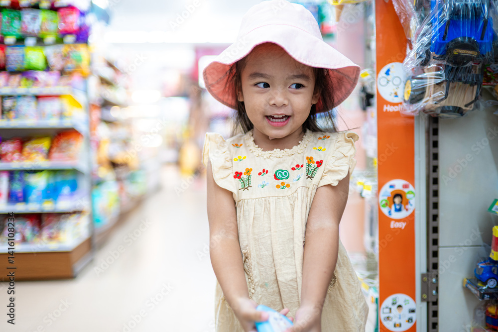Little girl enjoy shopping toy on shelf in supermarket