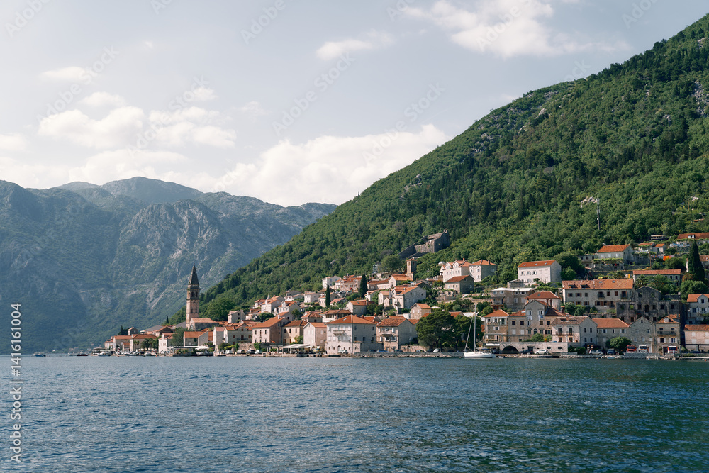View from the sea of the coast of Perast with old houses and the high bell tower of the church. Montenegro View from the sea of the coast of Perast with old houses and the high bell tower of the church. Montenegro