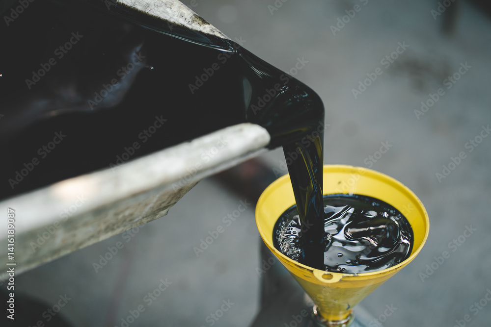 Old engine oil. Pouring old black oil of car engine from oil pan into bottle on top view lubrication used for recycle.