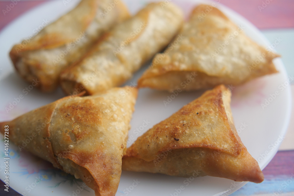 Crispy samosas served on a plate in a colorful setting Crispy samosas served on a plate in a colorful setting