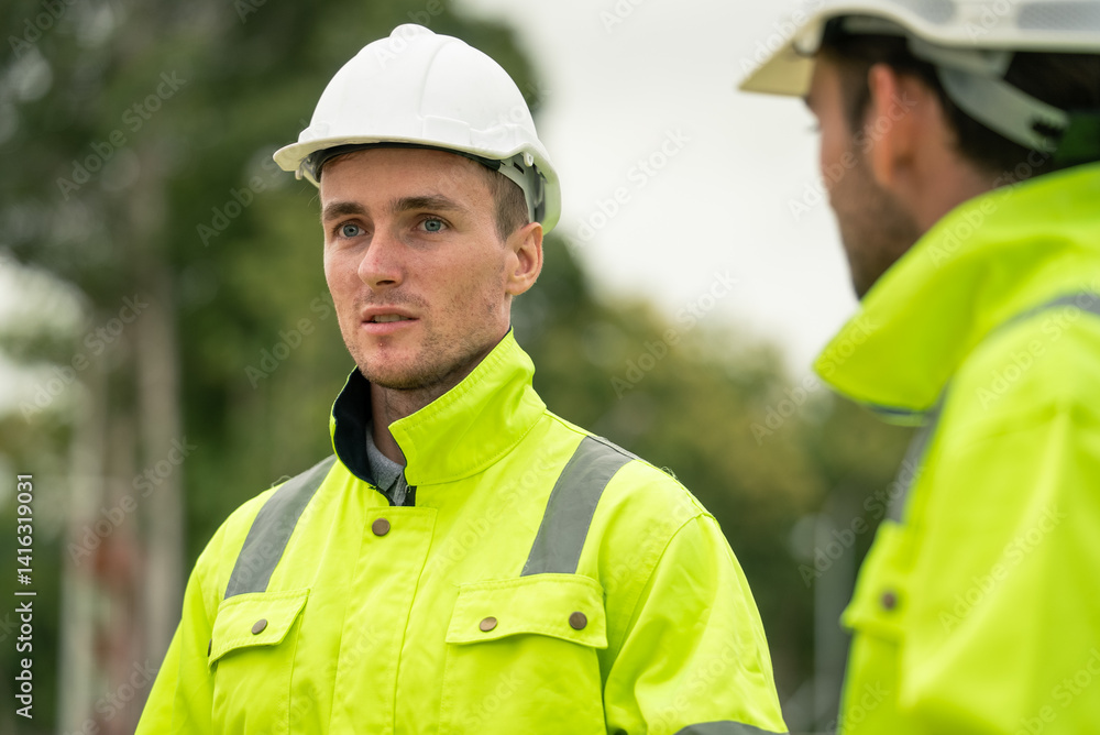 Engineer worker in protective uniform talking with colleagues at construction site Engineer worker in protective uniform talking with colleagues at construction site