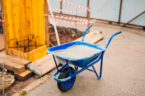 Fotografie Construction Wheelbarrow with Fresh Concrete on Site