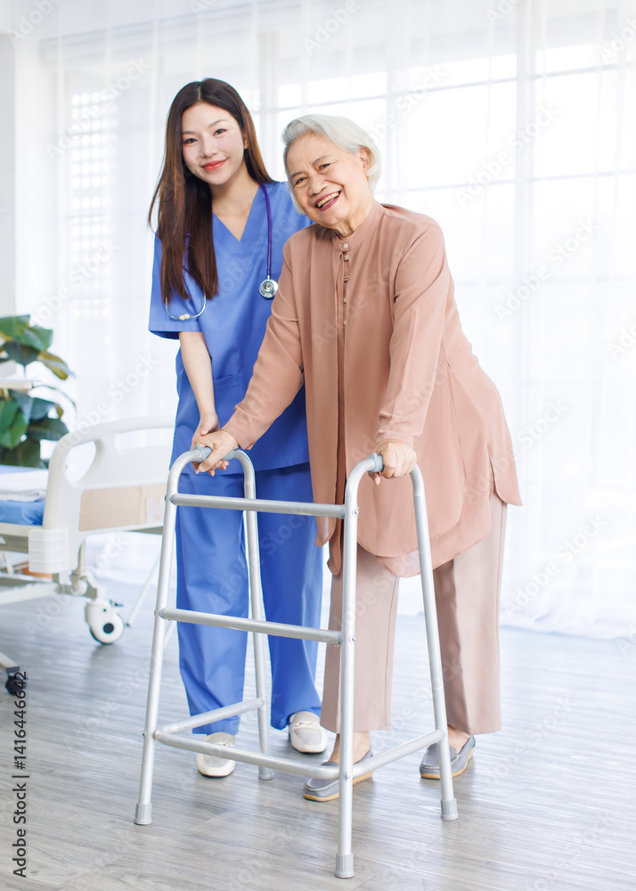 Asian doctor or caregiver helping assistance old woman to standing with walker in hospital, Young nurse supporting senior patient walk slowly frame nursing home care, Healthy wellness being concept.