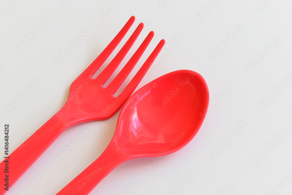 red spoon and fork isolated on white background, plastic cutlery for picnic