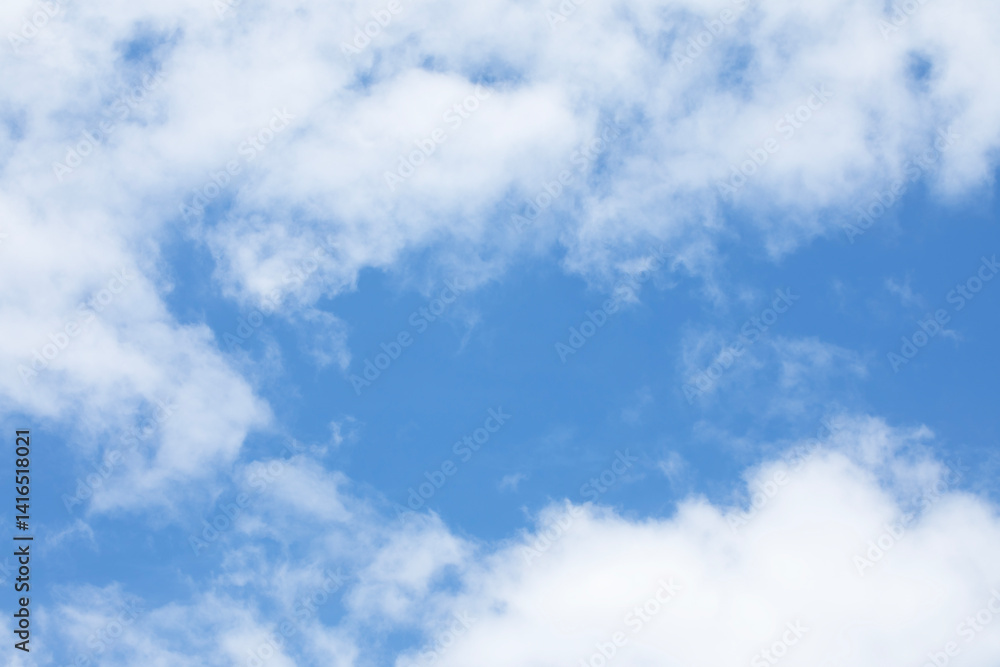 Blue sky background and white clouds soft focus, and empty space in middle, horizontal shape.