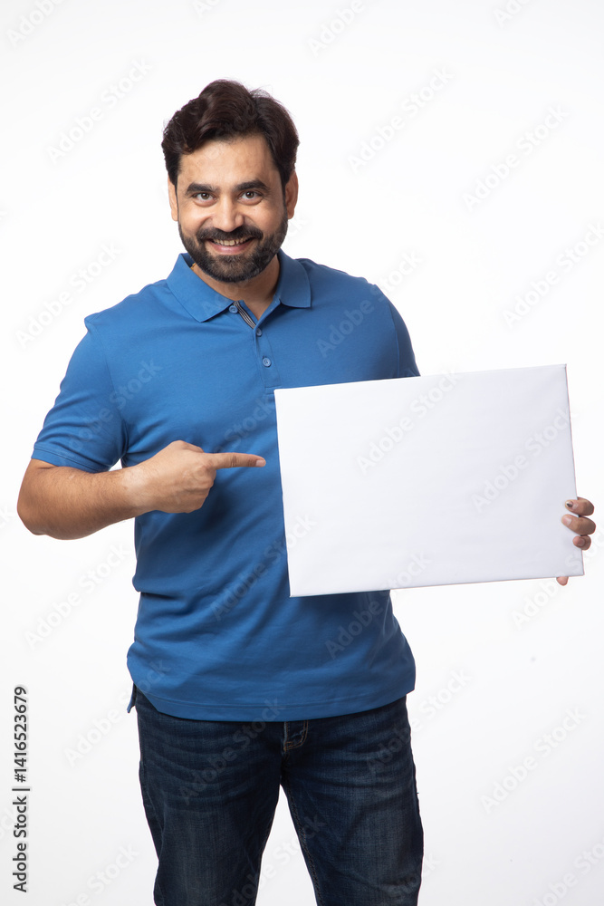Indian happy cheerful man pointing finger and showing white board, signage, banner on white background Indian happy cheerful man pointing finger and showing white board, signage, banner on white background