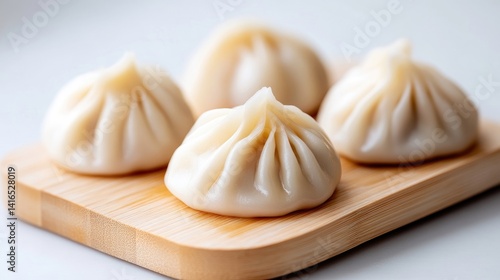 Wallpaper Mural Fresh, steamed dumplings on a wooden board.  Four delicate, light-colored dumplings rest attractively on a simple, light-brown wooden platter.  The pleats of the dough are clearly visible Torontodigital.ca