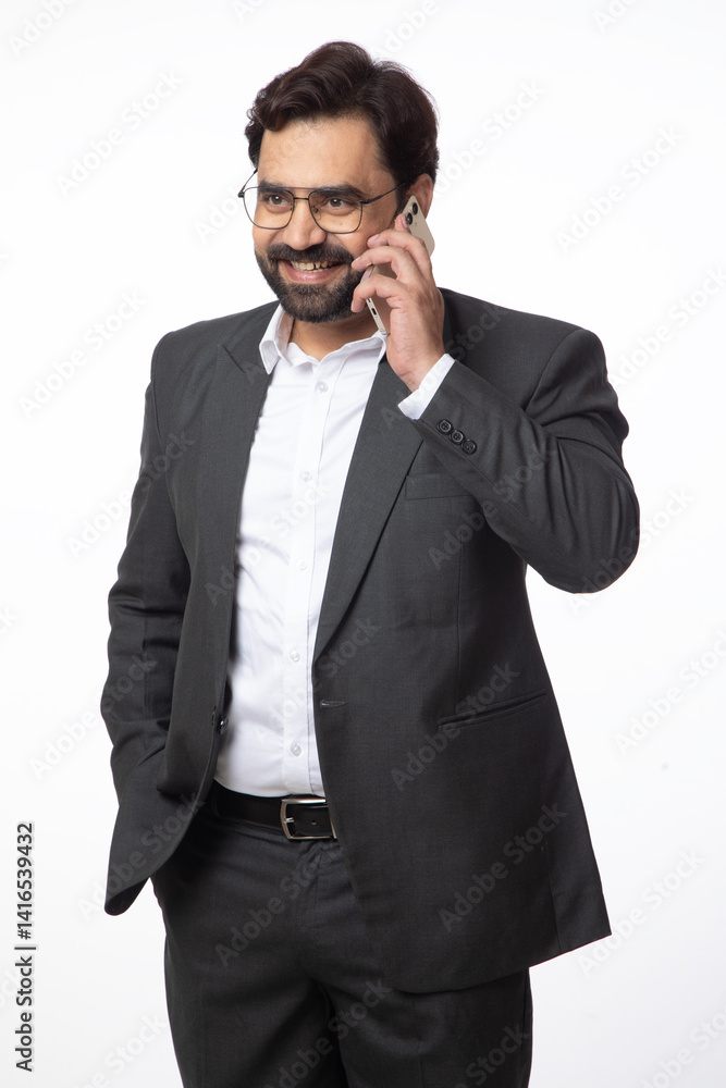 Indian happy business corporate man taking on mobile phone on white background. Concept of digital and business technology Indian happy business corporate man taking on mobile phone on white background. Concept of digital and business technology