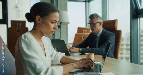 Photos Focused businesswoman working on laptop in office