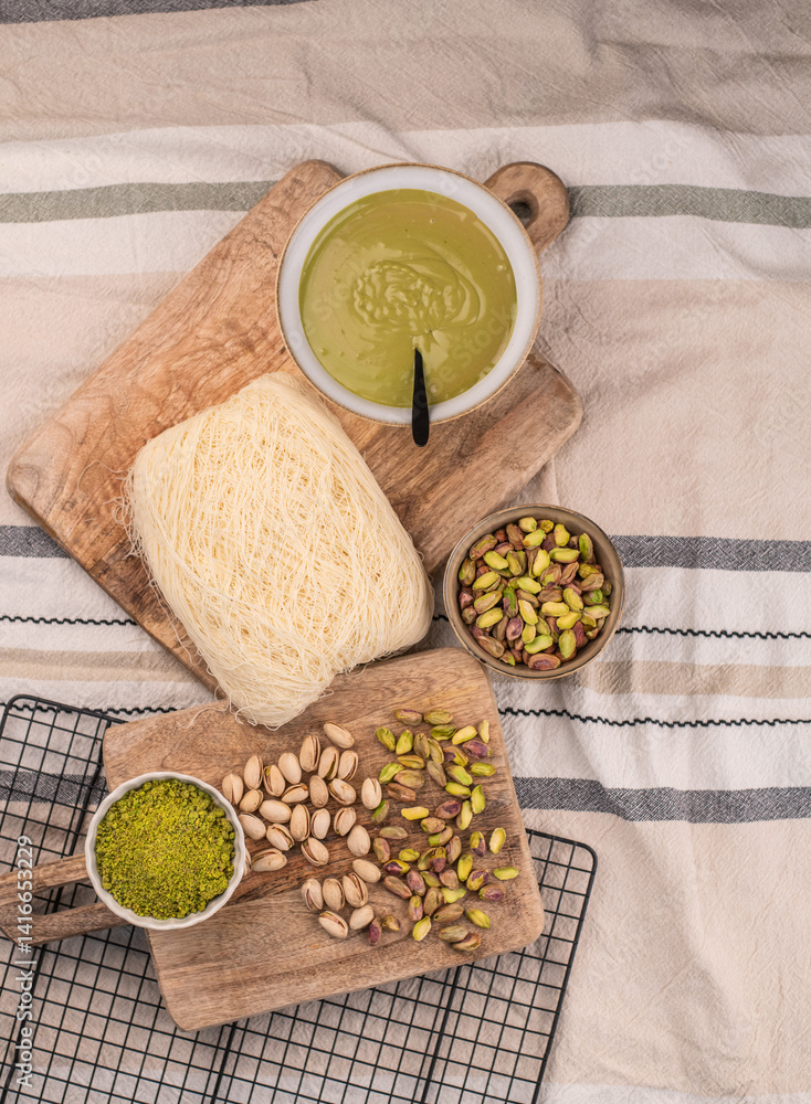 Zutaten für trendige Dubai-Schokolade mit Pistazie – Flatlay mit Fadenteig, Pistazien und Pistaziencreme Zutaten für trendige Dubai-Schokolade mit Pistazie – Flatlay mit Fadenteig, Pistazien und Pistaziencreme