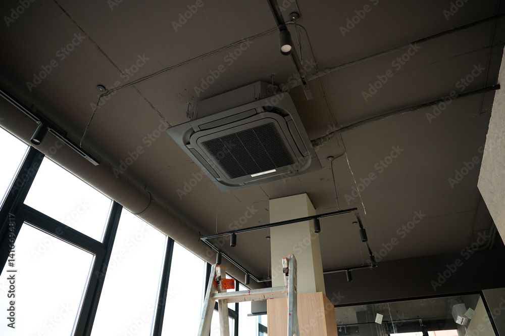 Obraz premium Ceiling mounted cassette air conditioner in modern building. Loft style. Industrial interior design.