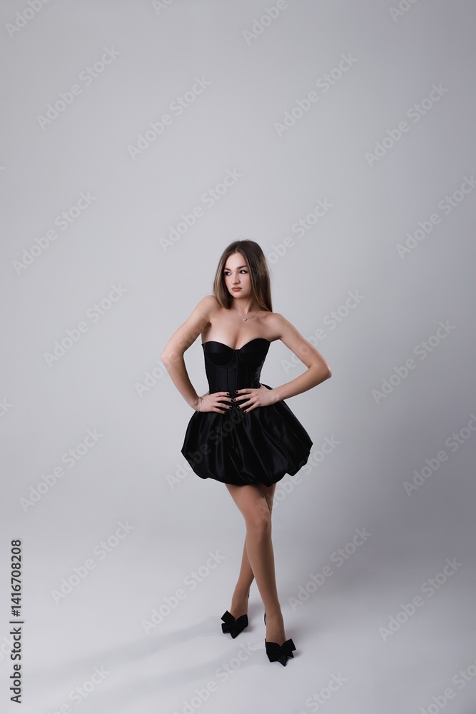 girl in black short dress in studio on white background girl in black short dress in studio on white background