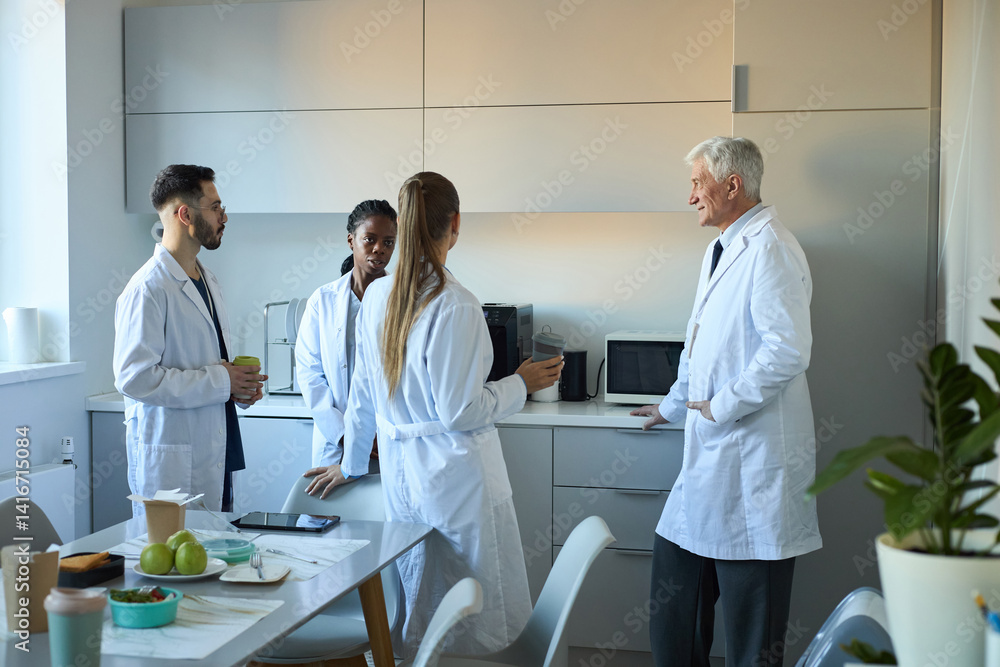 Group of scientists engaged in active discussion in bright, modern laboratory discussing research findings. Room filled with scientific equipment and casual workspace atmosphere Group of scientists engaged in active discussion in bright, modern laboratory discussing research findings. Room filled with scientific equipment and casual workspace atmosphere