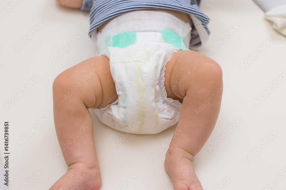Baby lying on table wearing clean diaper