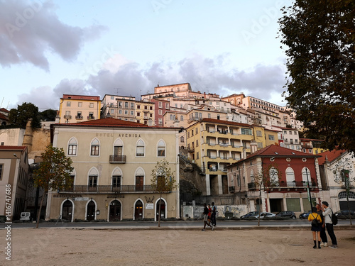 Ancient Portuguese city of Coimbra. View of street, built on hill, with old houses at sunset