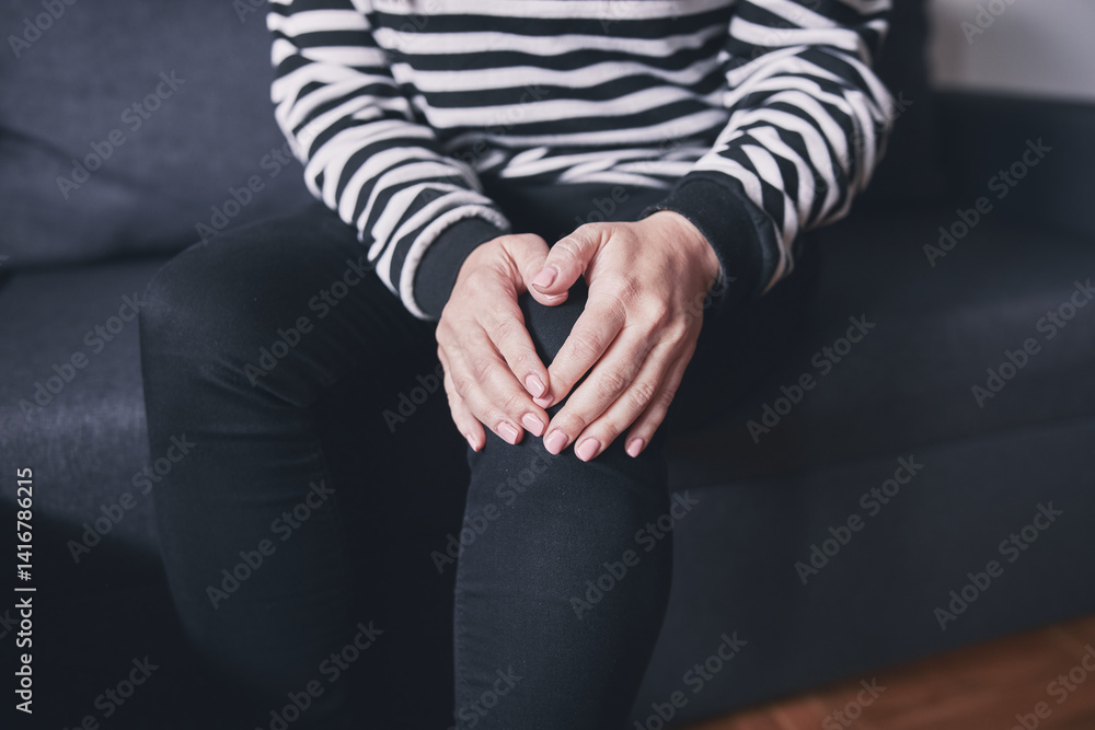 Woman with painful knee and leg injury at home.