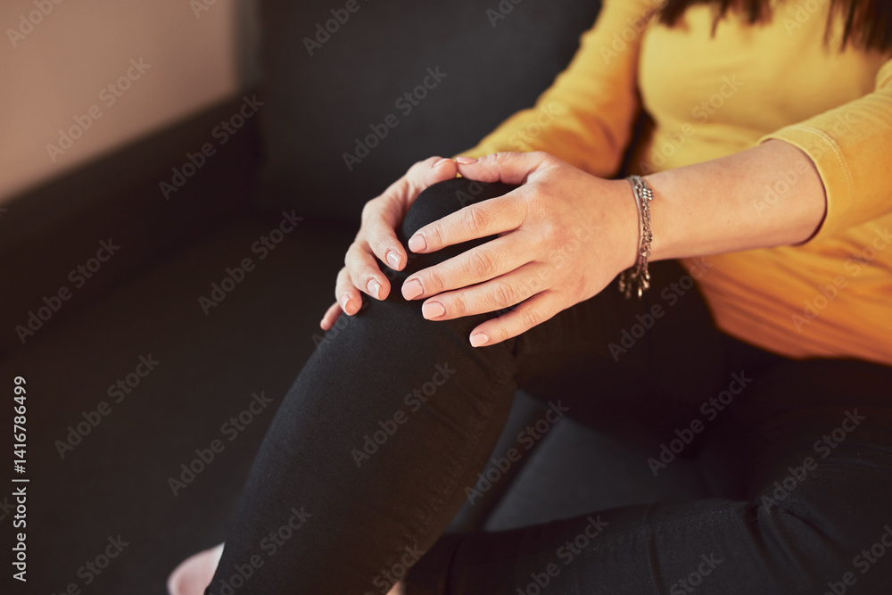Woman with painful knee and leg injury at home.