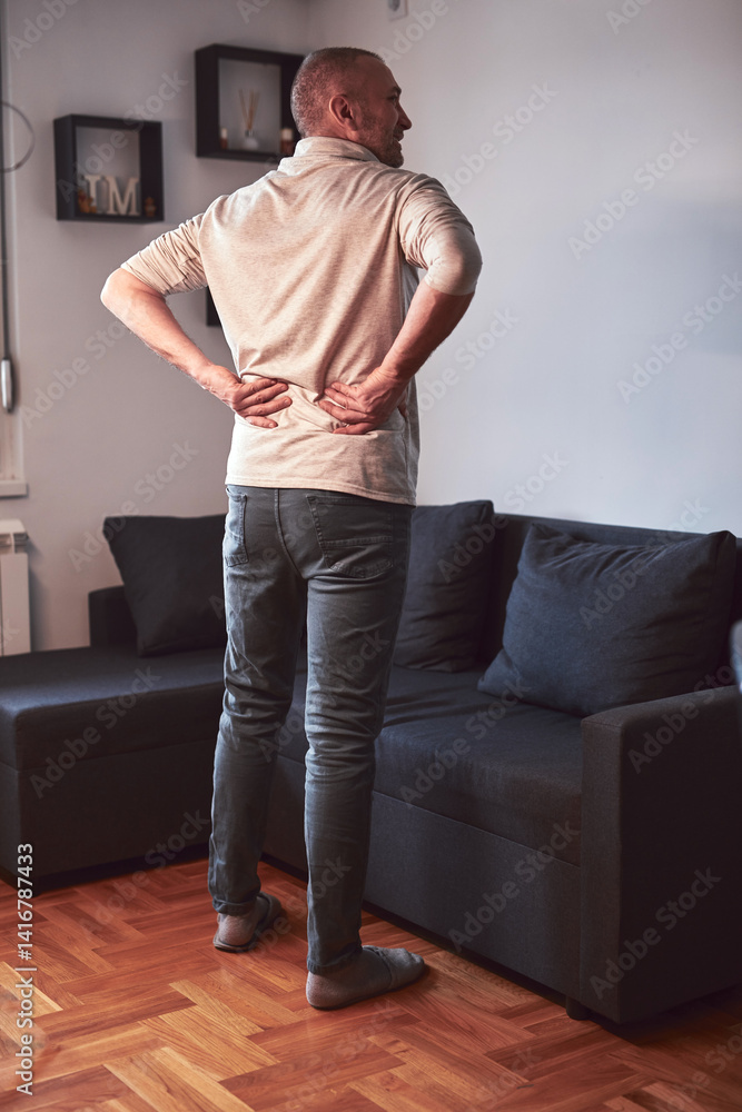 Man with hip, back and sciatica pain at home.