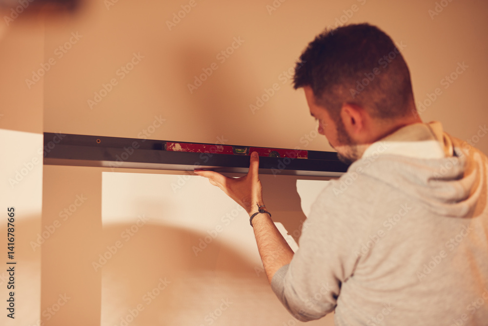 Handyman mounting and fixing kitchen cabinets and shelf.