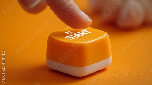 Close-up of a finger pressing an orange 'START' button on a vibrant surface.