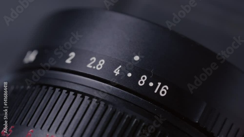 Closeup: Aperture ring changing on camera old Lens, adjusting F-Stop number and iris, showing aperture scale and ring shifting. Professional photographer adjusting lens aperture stop. Close up shot