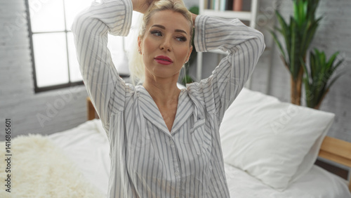 Woman relaxing in a cozy bedroom with white bedding, capturing a serene morning routine indoors, featuring an attractive blonde adult in striped pajamas. Free Download Woman relaxing in a cozy bedroom with white bedding, capturing a serene morning routine indoors, featuring an attractive blonde adult in striped pajamas. - GFXLoad