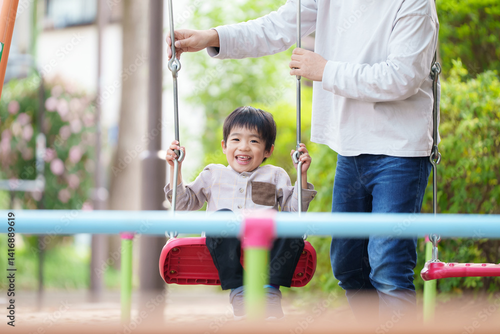 Obraz premium ブランコで遊ぶ5歳の男の子と40代の父親 