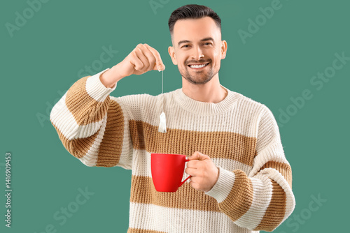 Young man dipping tea bag i...