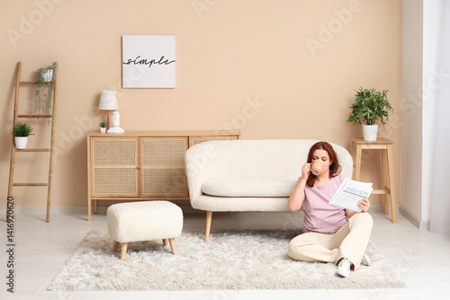 Obraz na płótnie Young woman with newspaper drinking tea on carpet at home w salonie