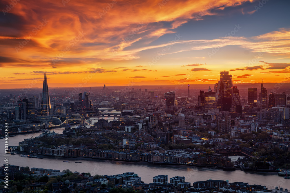 Elevated, panoramic view of the city skyline of London, England, during dusk with glowing colors and clouds