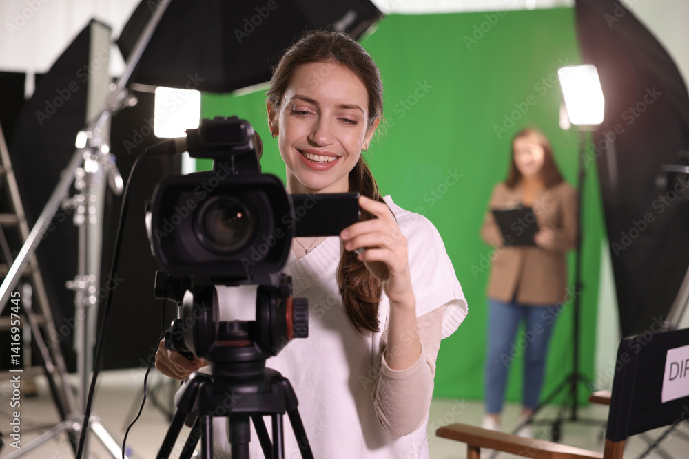 Happy camerawoman with camera in modern film studio