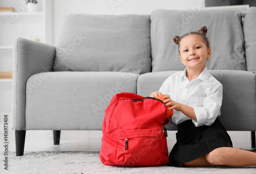 Little girl putting school ...